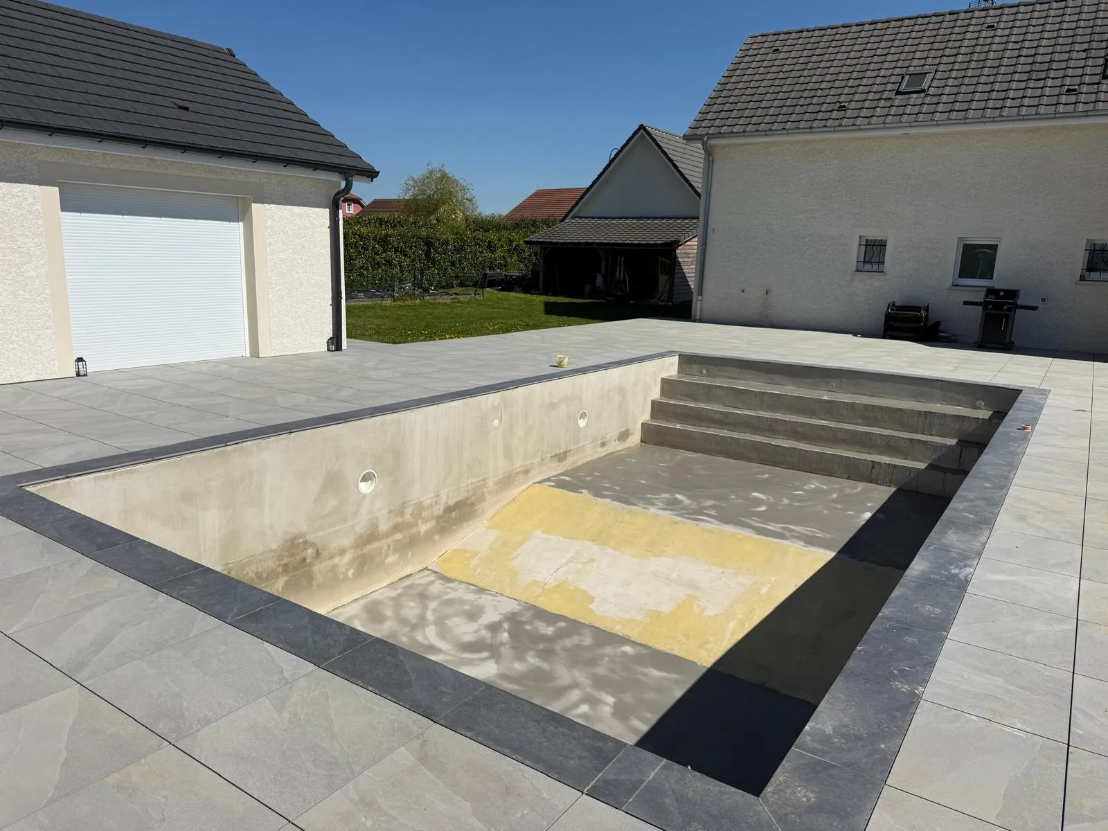 Plage de piscine et terrasse en béton réalisées par Altan — Aménagement extérieur en Haute-Saône